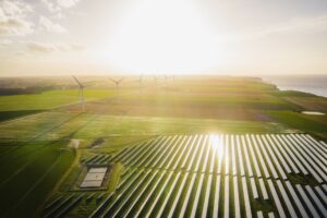 Wind turbines and solar panels farm in a field. Renewable green energy. Sunny landscape, electric energy generator for clean energy producing concept.